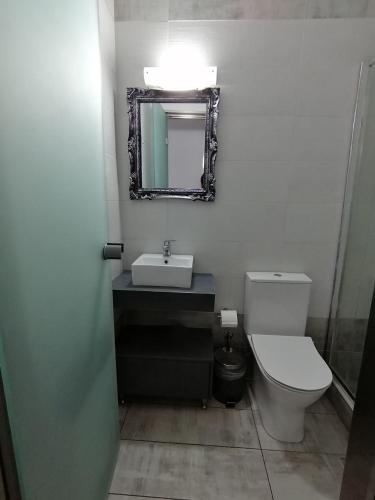 a bathroom with a toilet and a sink and a mirror at "ΙωΚαρ" in Nafpaktos