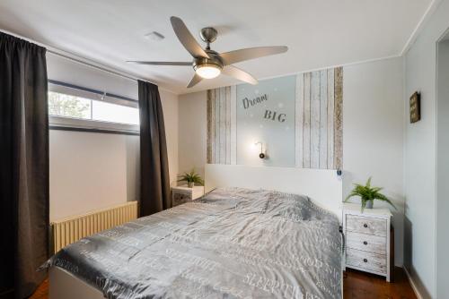 a bedroom with a bed and a ceiling fan at Bright and Comfortable Houseboat in Aalsmeer