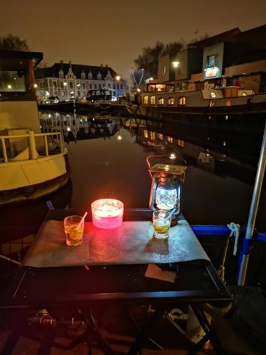 - une table avec deux bougies et un vase sur un bateau dans l'établissement La bigoudène, à Wambrechies
