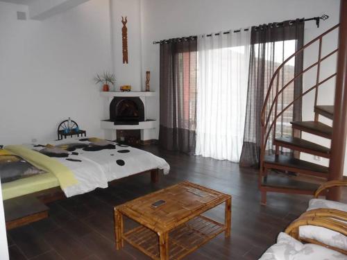 ein Schlafzimmer mit einem Bett, einer Treppe und einem Kamin in der Unterkunft Ecole Lodge Antananarivo in Mahitsy