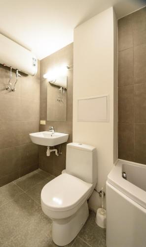 a bathroom with a white toilet and a sink at Partner Guest House in Kyiv