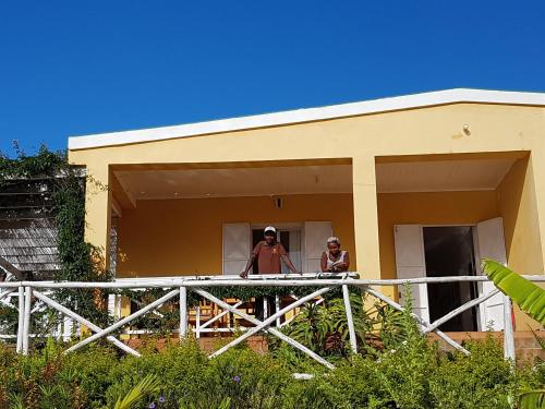 two people standing on the balcony of a house at Ecole Lodge Antananarivo in Mahitsy