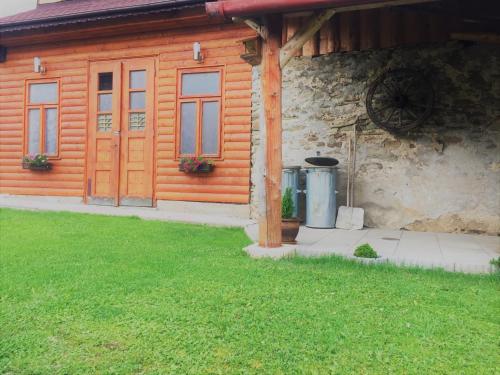 a log cabin with a door and two trash cans at Apartmány Rejdovian in Telgárt