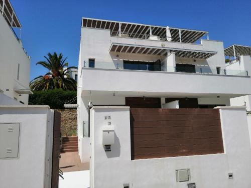 Un edificio blanco con paneles solares. en CASA LA ROCA, en Agua Amarga