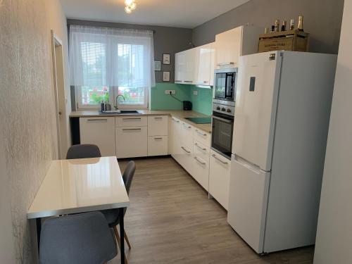 a kitchen with a white refrigerator and a table at Tolarova Apartmán in Pardubice