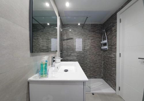 W łazience znajduje się biała umywalka i prysznic. w obiekcie Nice and sunny apartment w Corralejo
