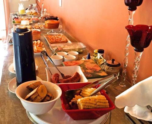 bufet z wieloma różnymi rodzajami żywności na stole w obiekcie Eco Pousada Quaresmeiras w mieście Domingos Martins