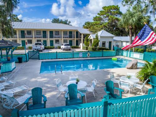 - une piscine avec des chaises et un drapeau américain dans l'établissement Steinhatchee River Inn and Marina, à Steinhatchee