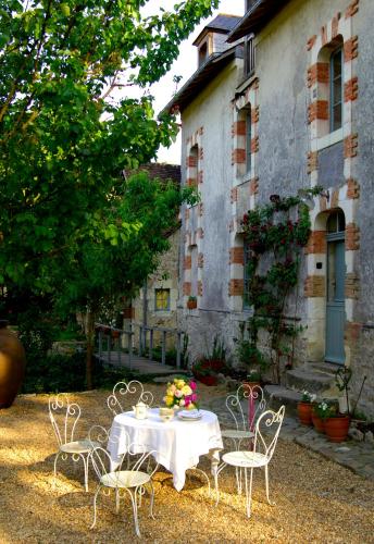 a table and chairs in front of a building at Le Moulin Bregeon in Linières-Bouton