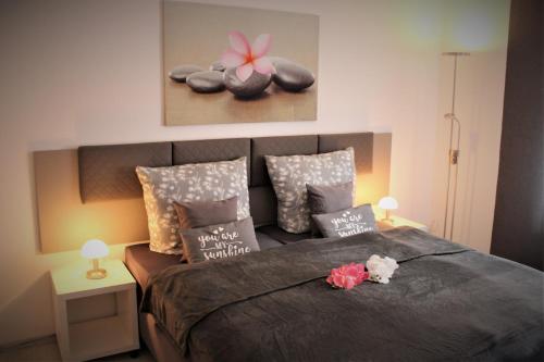 a bedroom with a bed with pillows and flowers on it at SALZHAUSBLICK BUSINESS APARTMENTS - Zentrale Lage am Salzhaus - MwSt-Rechnung verfügbar in Zittau