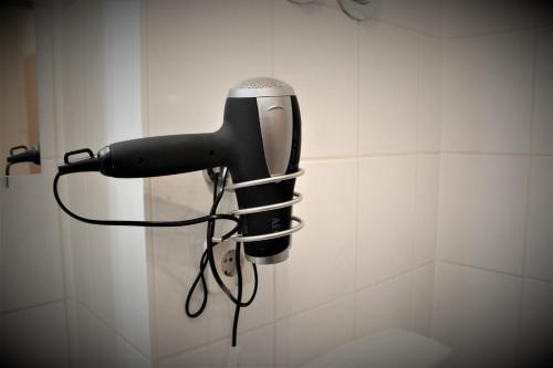 a blow dryer is hanging on a wall at SALZHAUSBLICK BUSINESS APARTMENTS - Zentrale Lage am Salzhaus - MwSt-Rechnung verfügbar in Zittau