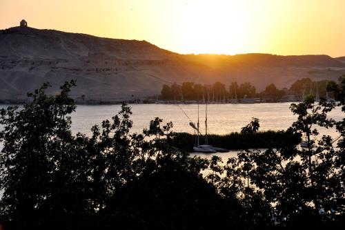 a sunset over a body of water with boats in it at Marhaba Palace Hotel in Aswan