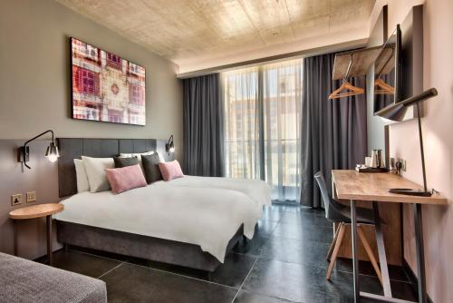 a hotel room with two beds and a desk at Number 11 St Julian's Malta - Handwritten Collection in St Julian's