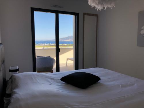 une chambre avec un lit avec vue sur la plage dans l'établissement T2 climatisé à Porticcio, 100m de la plage wifi fibre, à Porticcio