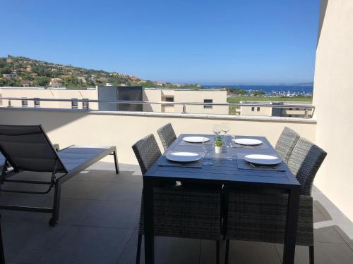 une table bleue et des chaises sur un balcon dans l'établissement T2 climatisé à Porticcio, 100m de la plage wifi fibre, à Porticcio
