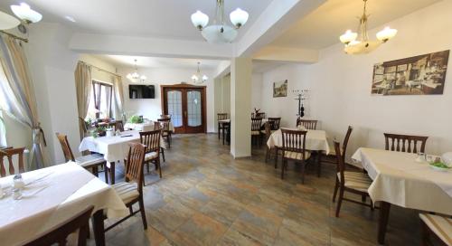 ブラショヴにあるPension Deutsches Hausの部屋にテーブルと椅子があるレストラン