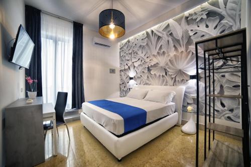 a bedroom with a bed and a desk and a tv at Le Corti del Re in Naples