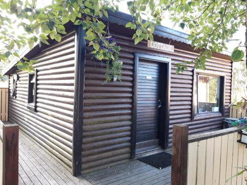 a wooden cabin with a door on a deck at Country Dream - Langholt 2 in Selfoss