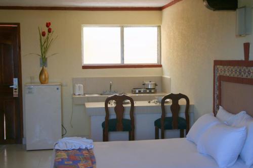 cocina con 1 cama y 2 sillas en una habitación en Suites Cancun Center, en Cancún