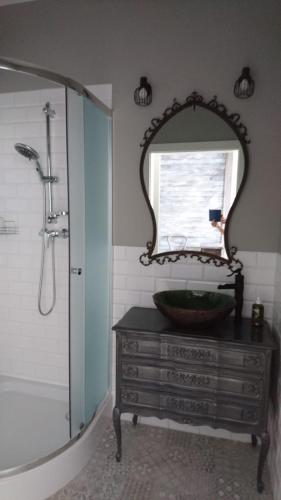 Gościnna Prowansja في ووكوف: حمام مع حوض ومرآة على خزانة الملابس