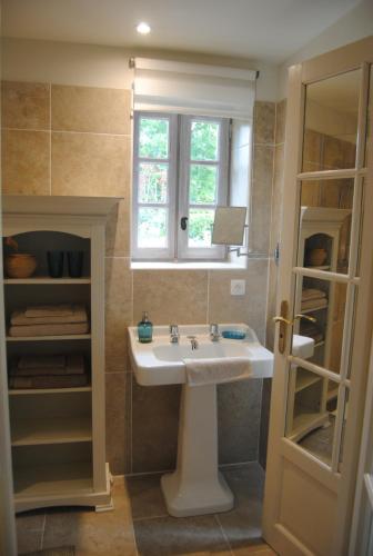 een badkamer met een wastafel en een raam bij Domaine de la Charmeraie in Saint-Cirq