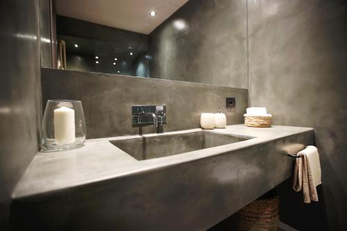 a bathroom with a sink with two candles on it at Casa Nostra Boutique Hotel & Spa in Palermo
