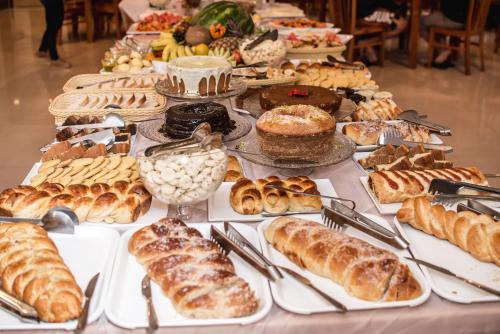 a table filled with different types of pastries and pies at Hotel Recanto do Ouro in Ouro Preto