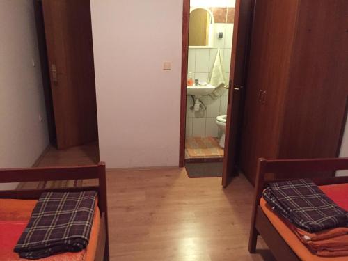 a room with two beds and a bathroom with a mirror at Sobe Matea - prenoćište in Vinkovci