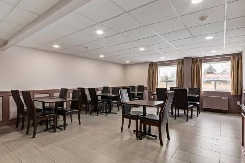 a waiting room with tables and chairs in a building at Airport Traveller's Inn in Calgary
