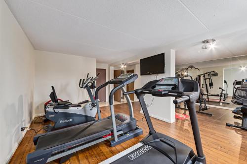 a gym with two exercise bikes and a television at Airport Traveller's Inn in Calgary