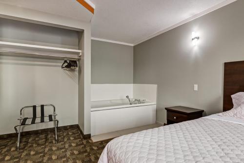 a bedroom with a bed and a bath tub at Airport Traveller's Inn in Calgary