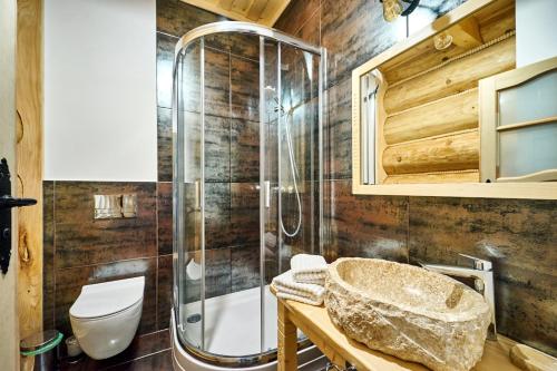 La salle de bains est pourvue d'une douche et d'un lavabo en pierre. dans l'établissement Osada nad potokiem, à Kościelisko
