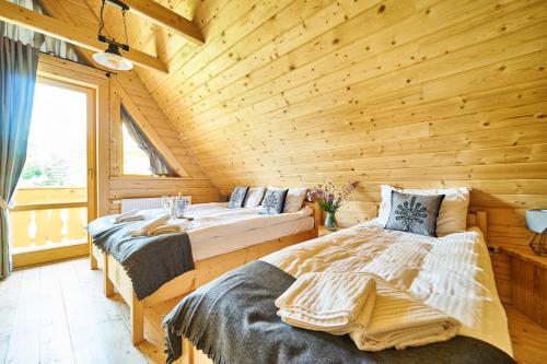 - une chambre avec 2 lits dans une cabane en rondins dans l'établissement Osada nad potokiem, à Kościelisko