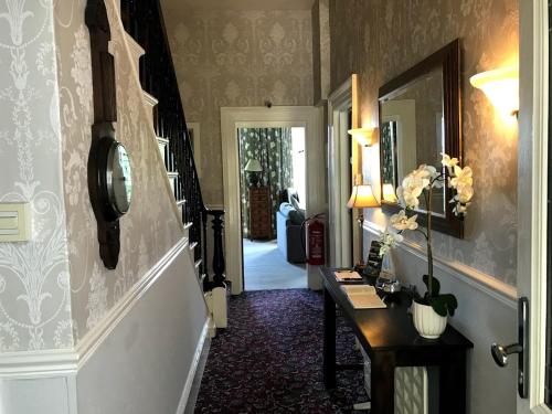 a hallway with a table and a mirror at The Collingdale Guest House in Ilfracombe