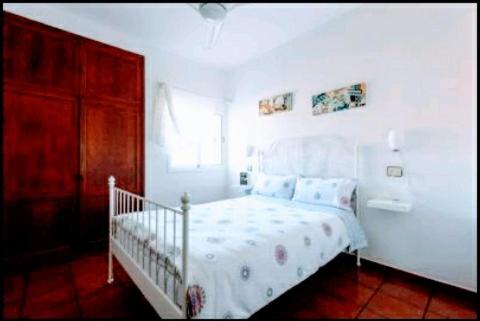 Un dormitorio blanco con una cama blanca y una ventana. en Makondo, en Agaete