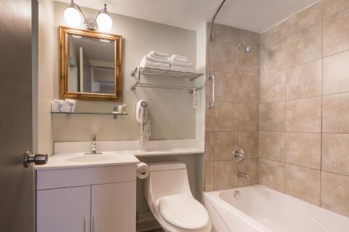 a bathroom with a sink and a toilet and a tub at Kent Inn in Lindsay