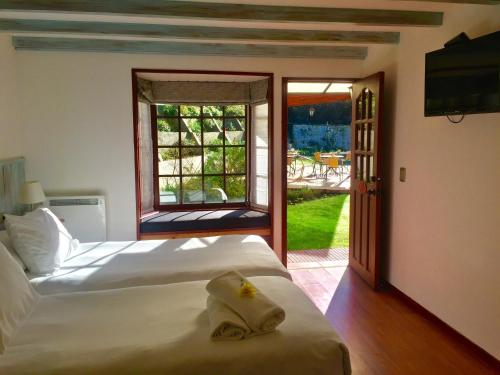 a bedroom with a bed and a sliding glass door at Hotel Frutillar in Frutillar