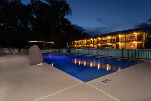 a swimming pool in front of a building at night at Steinhatchee River Inn and Marina in Steinhatchee