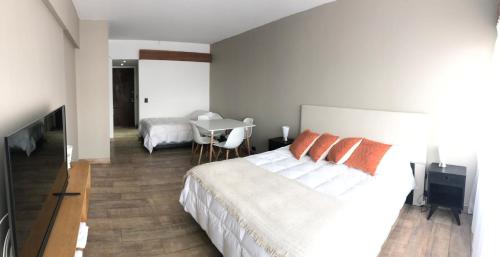 a bedroom with a bed and a table and a desk at Bariloche View Apartment in San Carlos de Bariloche