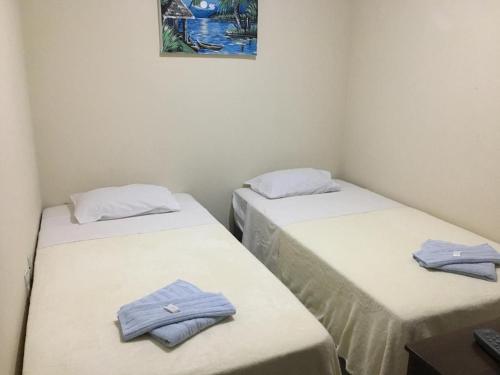 two beds in a room with towels on them at Hospedaria Casa da Lia in Mucugê