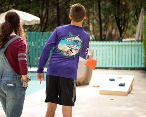 a young man and a woman looking at a kite at Steinhatchee River Inn and Marina in Steinhatchee