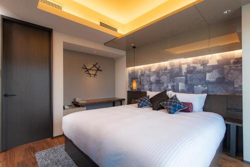a bedroom with a large white bed in a room at THE BLOSSOM HIBIYA in Tokyo