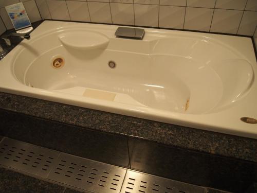 Kunitachi的住宿－Hotel Cherena Kunitachi (Adult Only)，白色浴缸位于柜台上