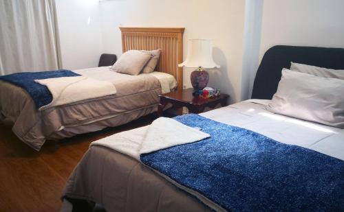 a bedroom with two beds and a table with a lamp at GA STAY in Oakville