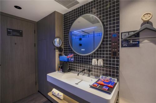 a bathroom with a sink and a mirror at Fenk Attitude Hotel Guangzhou Railway Station in Guangzhou