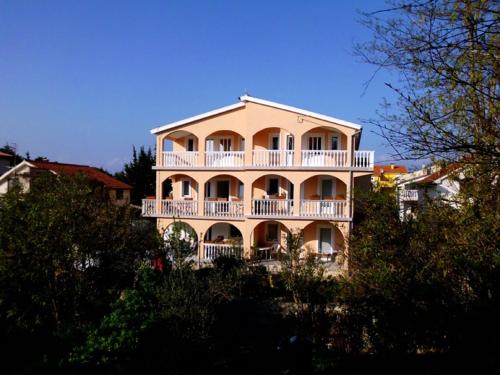 een groot gebouw met een balkon. bij Apartments Dujlovic in Privlaka