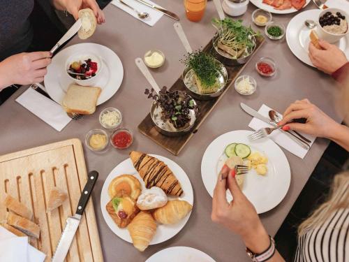 a group of people sitting at a table with plates of food at Mercure Hotel Düsseldorf Neuss in Neuss