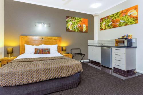 a hotel room with a bed and a microwave at Quality Hotel Darwin Airport in Darwin