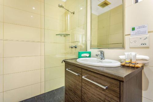 uma casa de banho com um lavatório e um chuveiro em Quality Hotel Darwin Airport em Darwin