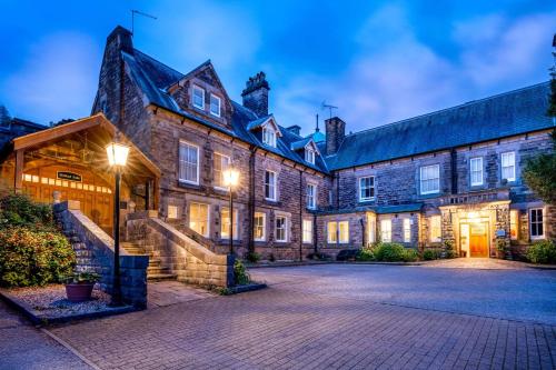 an old stone building with a staircase in front of it at Makeney Hall Hotel in Derby
